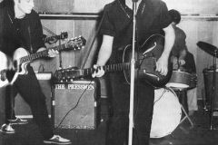 1960, May 10, John Lennon and Paul McCartney during an audition for Larry Parnes at the Wyvern Social Club, 108 Seel Street, Liverpool. Stuart Sutcliffe and Tommy Moore are behind them.