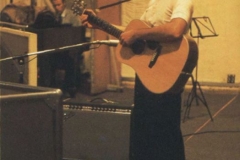 Paul barefoot at the studio playing an acoustic guitar (Martin D-28) and George Martin on piano, circa 1968.