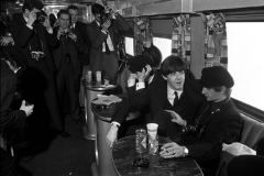 The Beatles 1964 US Tour, 11th February, 1964, British pop group The Beatles have their pictures taken by a group of photographers as they sit at a table with a drink of Coca Cola on the train from New York to Washington during their tour of the States (Photo by Popperfoto/Getty Images)