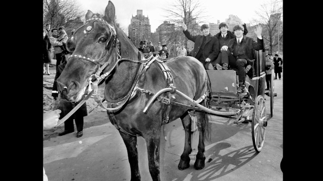 Three of The Beatles -- from left, Ringo Starr, Paul McCartney and John Lennon -- wave from a horse-drawn carriage in New York's Central Park on February 8, 1964. George Harrison was off resting a sore throat