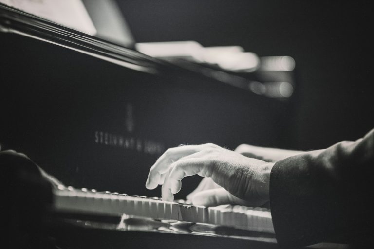 Acoustic piano keys in warm studio light evoking John Lennon intimate songwriting on Mind Games