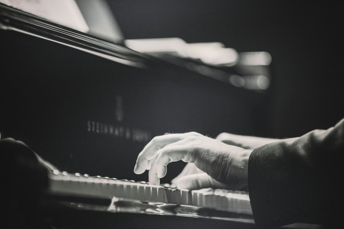 Acoustic piano keys in warm studio light evoking John Lennon intimate songwriting on Mind Games